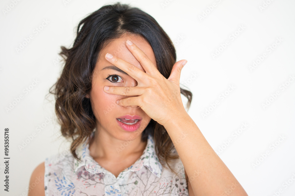Portrait of afraid young woman covering her face Portrait of afraid young woman covering her face