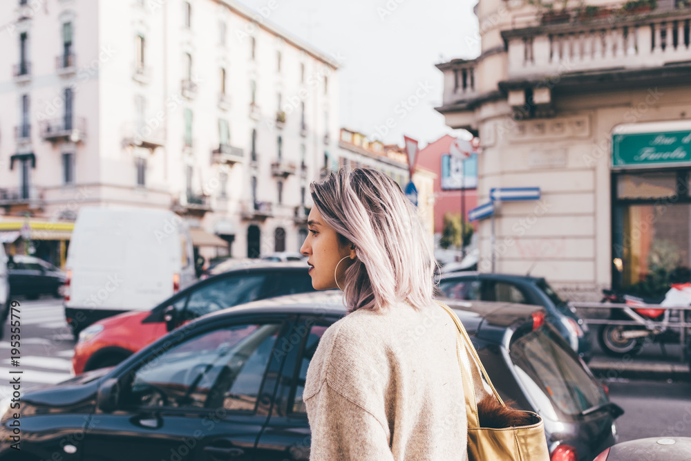 Waist up of young beautiful caucasian purple grey hair woman outdoor in the city looking over, smiling - happiness, carefree, serene concept