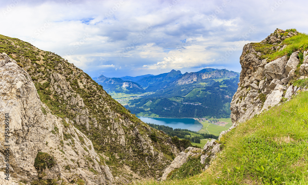 Fototapeta premium Aufnahme des Haldensee im Tannheimer Tal aus Richtung Krinnenspitze fotografiert tagsüber bei bewölktem Himmel im Sommer 2014