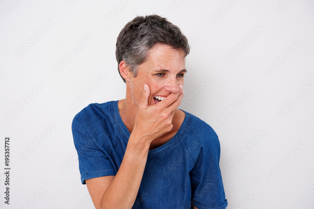 attractive older woman laughing with hand covering mouth attractive older woman laughing with hand covering mouth