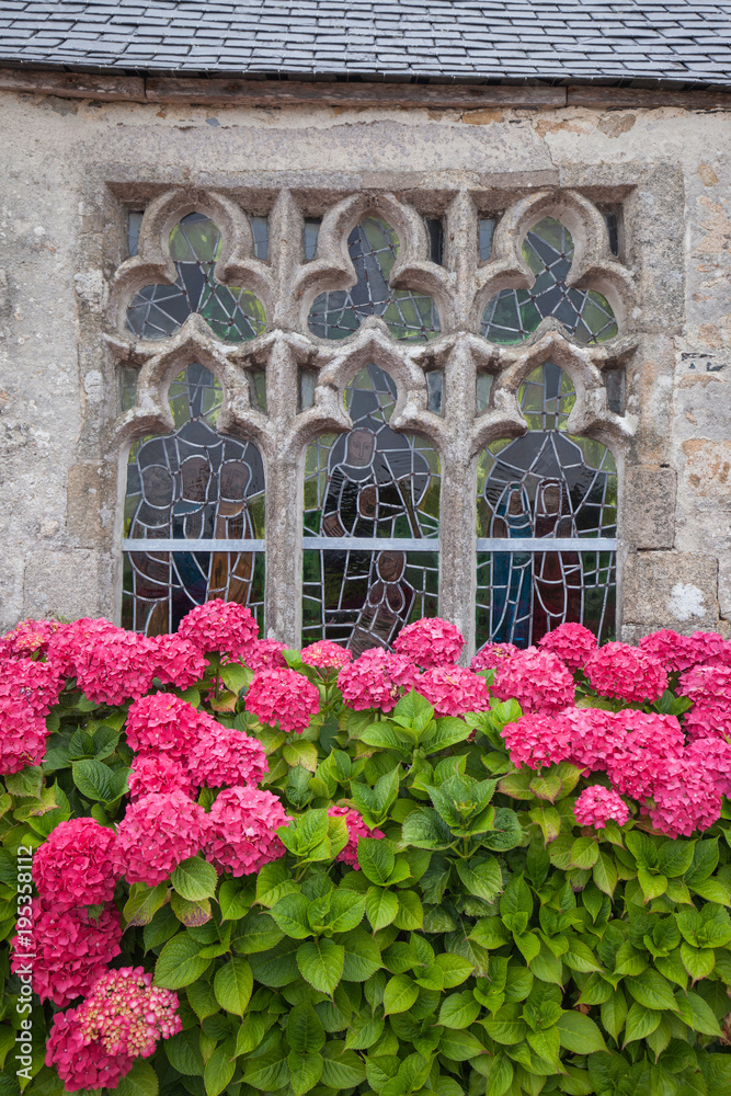 Ancient decorative window with stained glass and hydrangea flowers