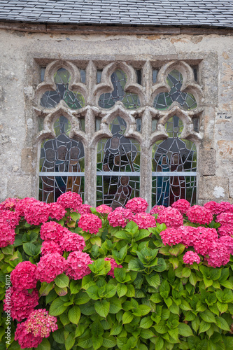 Ancient decorative window with stained glass and hydrangea flowers