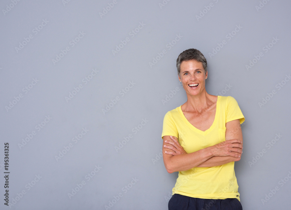 confident older woman smiling against gray background confident older woman smiling against gray background