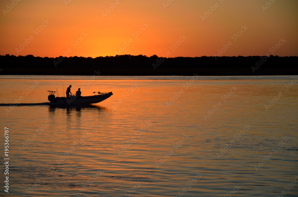 Boat returning on the river at sunset