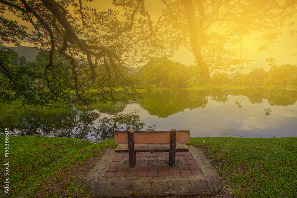 Single lonely chair near the nature lake during sunrise.