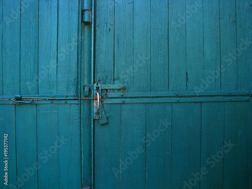 Bright blue color vintage wooden gates with door handle and latch