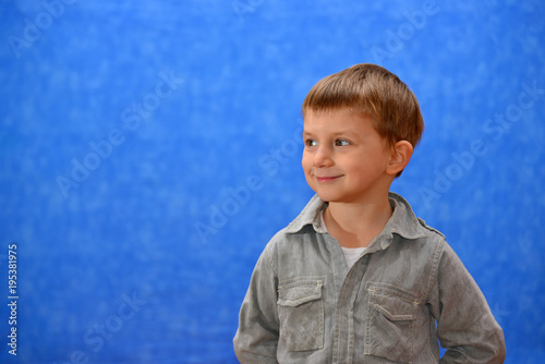 Boy in the studio on a blue background looking out into the distance