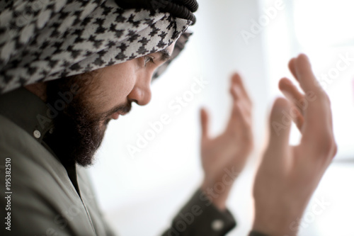Young Muslim man praying, c...