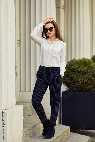 Young pretty woman walk on the street wear glasses and office clothing, spring time