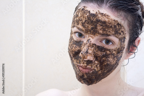 Caucasian model between age 20-29 years using a coffee face scrub for her face and eye bags.