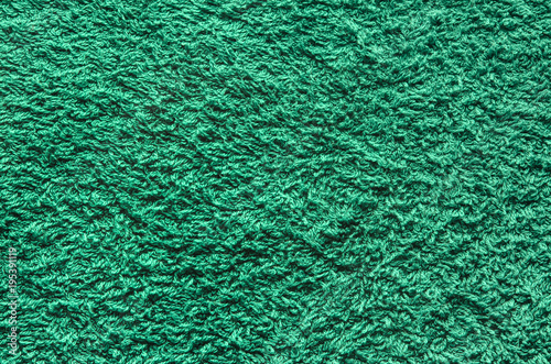 Abstract background of shaggy green carpet pile. Cloth texture with long fibers