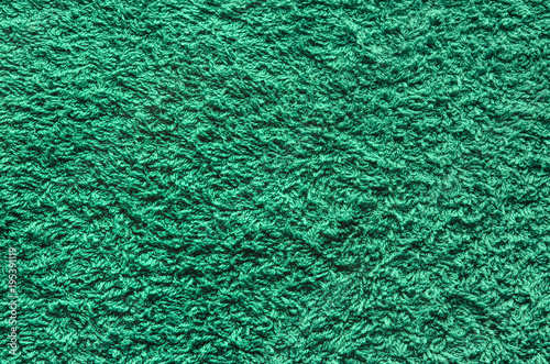 Abstract background of shaggy green carpet pile. Cloth texture with long fibers photo