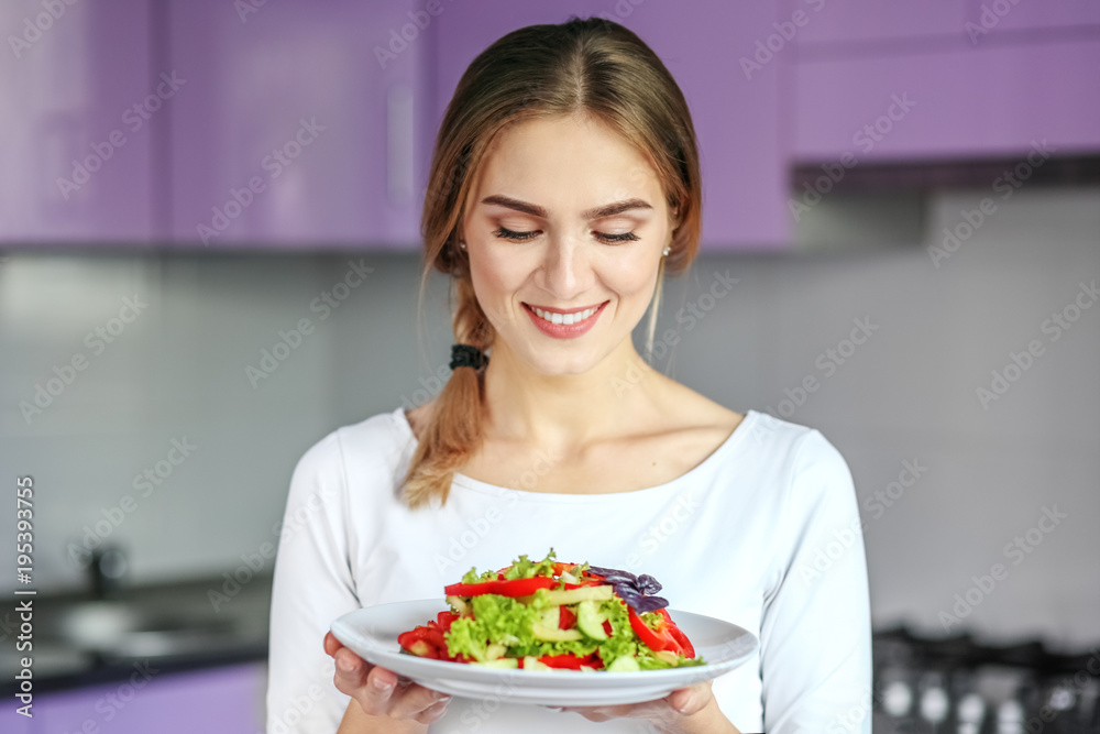 A beautiful young woman is a vegetarian. A girl with a plate of salad. The concept is healthy food, diet, vegetarianism, weight loss. A beautiful young woman is a vegetarian. A girl with a plate of salad. The concept is healthy food, diet, vegetarianism, weight loss.