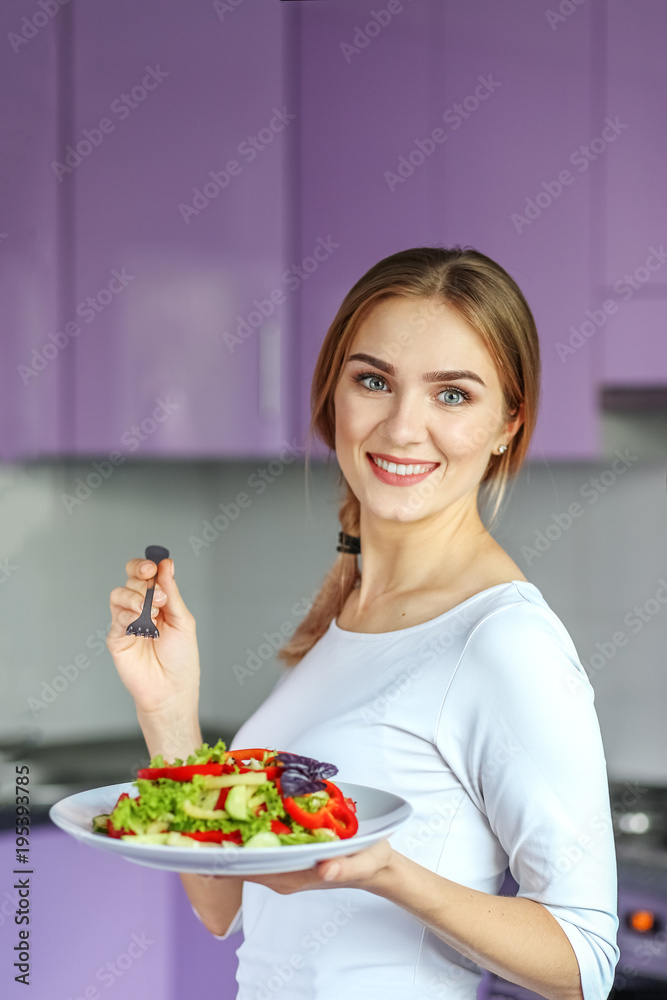Smiling young girl eating vegetable salad. The concept is healthy food, diet, vegetarianism, weight loss.