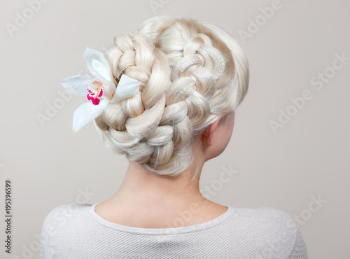 Beautiful girl with blonde hair, hairdresser weaves a braid close-up, in a beauty salon. Professional hair care and creating hairstyles.