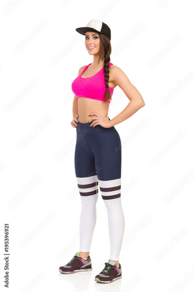 Beautiful Woman In Sports Clothes And Cap Is Standing And Smiling Beautiful Woman In Sports Clothes And Cap Is Standing And Smiling