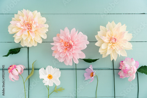 Crepe paper flowers dahlias, cosmos and echinacea on turquoise wooden background