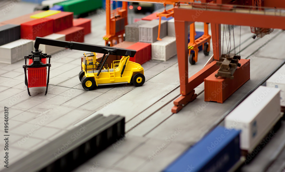 Fototapeta premium Toy loader carrying a container in a layout of a cargo hub