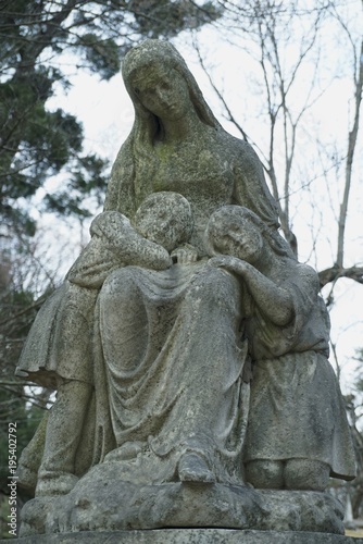 old carved stone figure on grave women gravestone in graveyard  memorial angel on tombstone