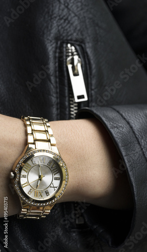 Woman in a leather jacket and with a clock on her arm