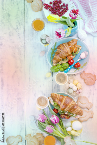 Fototapeta Naklejka Na Ścianę i Meble -  Background Easter. For breakfast Croissants with salad and espresso. Fresh juice and sweets. Spring tulips. Easter decor. White wooden background.