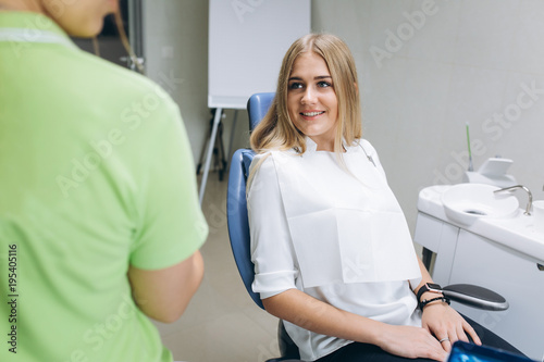 The dentist teaching a girl oral hygiene on braces in a dental clinic.