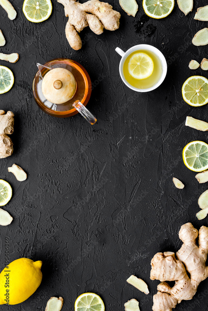 Tea for cure colds. Cup, teapot, ginger root and lemon on black background top view copy space Tea for cure colds. Cup, teapot, ginger root and lemon on black background top view copy space
