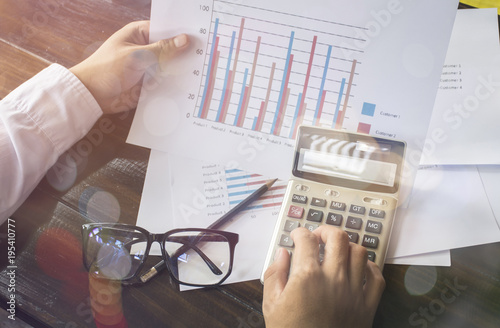 Foto Businessmen use the calculator to calculate and analyze the comp