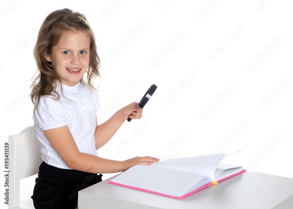 A little girl looks through a magnifying glass A little girl looks through a magnifying glass