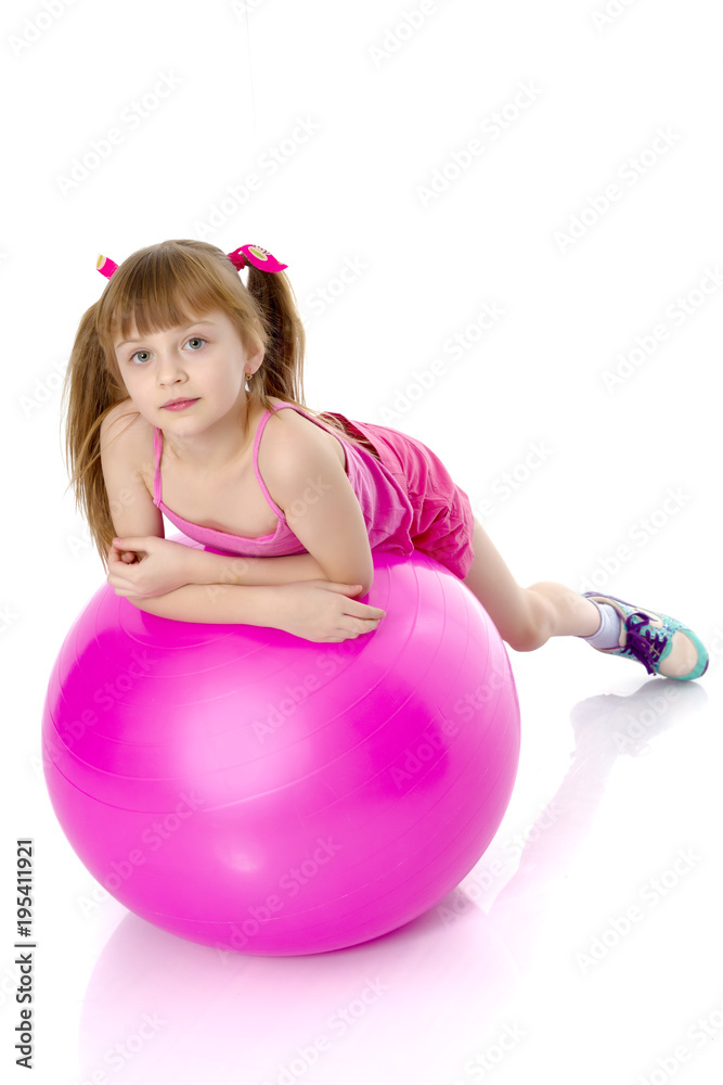 little girl doing exercises on a big ball for fitness. Stock Photo