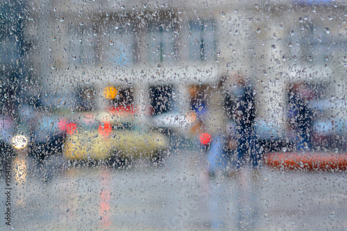Raindrops on the glass against blurred city street scene