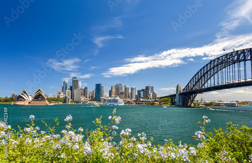 Stunning wide angle city skyline view of the Sydney CBD harbour area at Circular Quay with the opera and the harbour bridge. Seen from Dr Mary Booth Lookout in Kirribilli, Sydney, Australia.