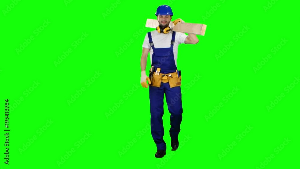 Builder in a helmet goes to work with wooden boards in his hands. Green screen Builder in a helmet goes to work with wooden boards in his hands. Green screen