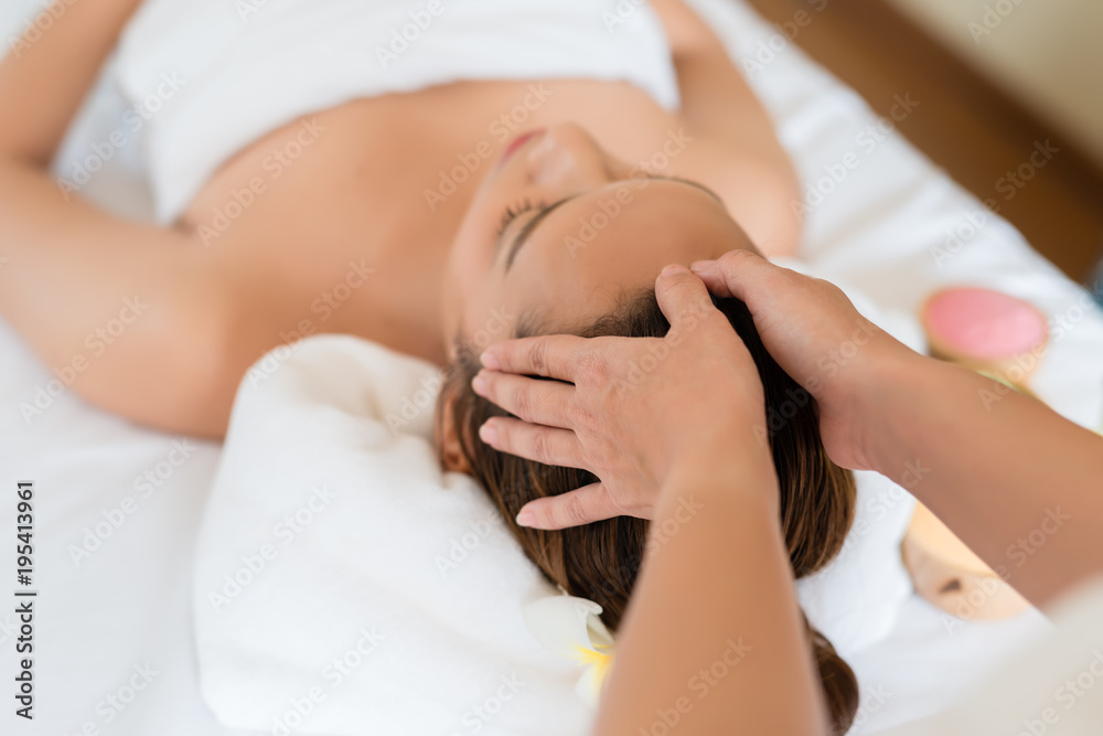 Beautiful Asian girl relaxing receiving facial massage in a spa salon Beautiful Asian girl relaxing receiving facial massage in a spa salon