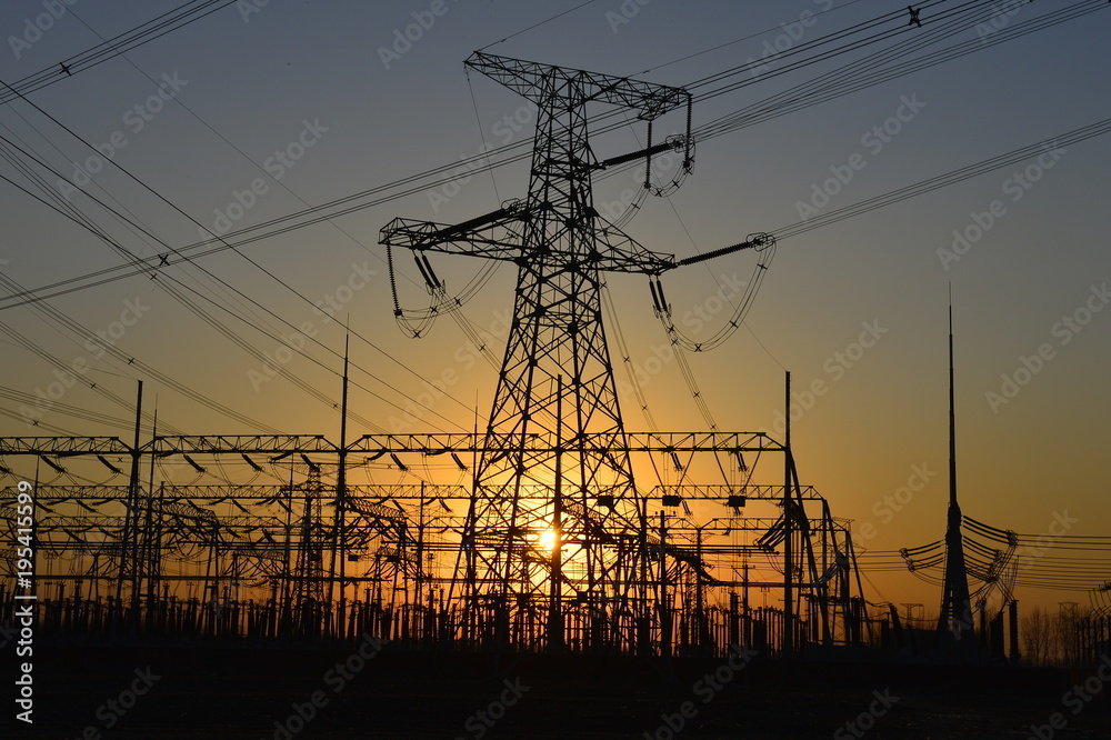 Fototapeta premium The silhouette of the evening electricity transmission pylon