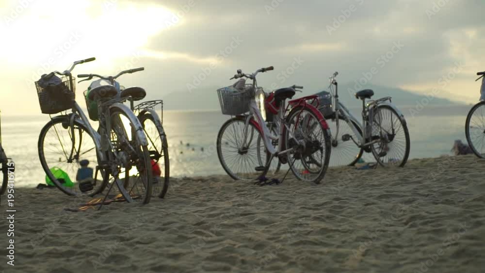 many bicycles parking on a sand at city beach at sunrise many bicycles parking on a sand at city beach at sunrise