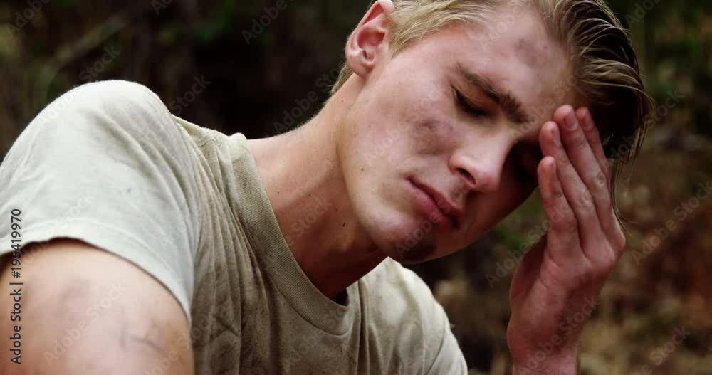 Unhappy military soldier relaxing at boot camp 