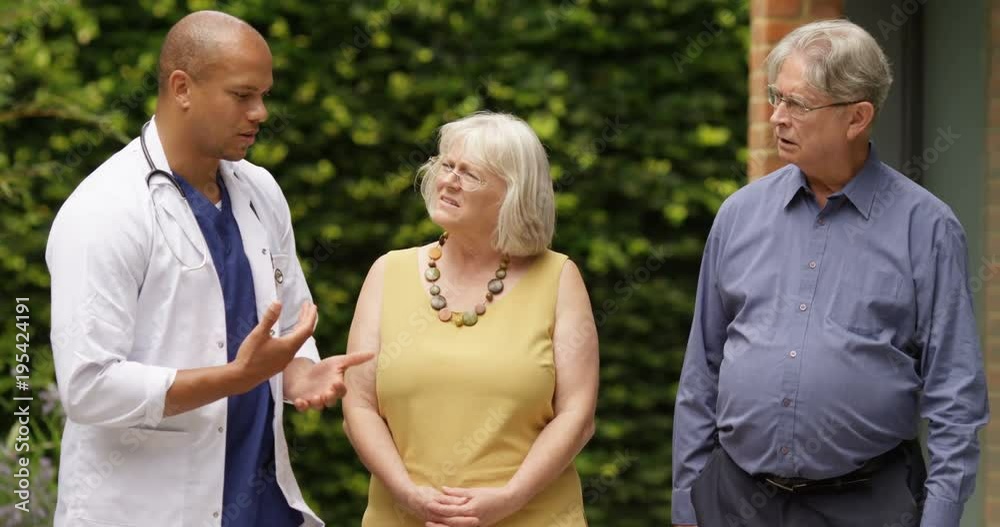 4K Doctor having to give bad news to upset senior couple outside hospital. Slow motion 4K Doctor having to give bad news to upset senior couple outside hospital. Slow motion