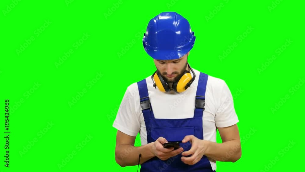 Engineer dials a message on his phone. Green screen Engineer dials a message on his phone. Green screen