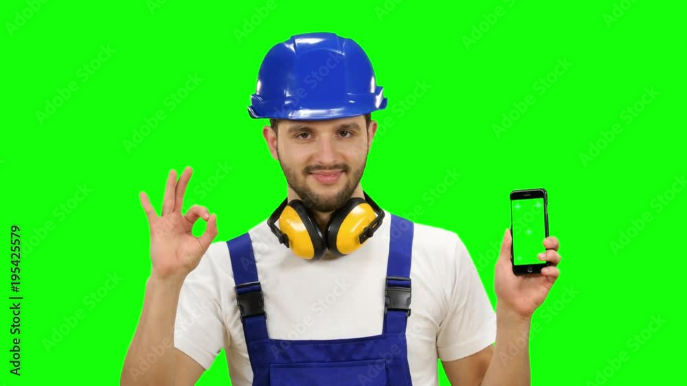 Foreman holds a phone in his hands and shows a thumbs up. Green screen. Mock up