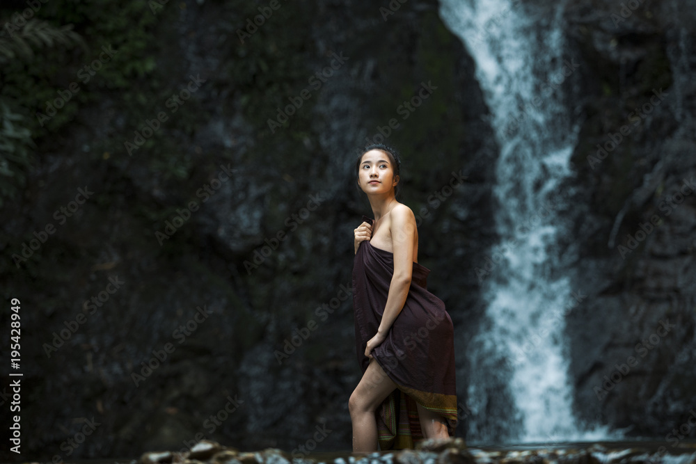 Young beauty woman standing on the waterfall Young beauty woman standing on the waterfall