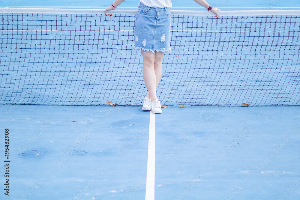 Close up young sport women legs on white lines of blue tennins court