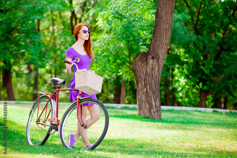 Young redhead girl with bike