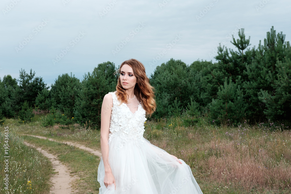 young pretty bride in white wedding dress outdoors, make up and hairstyle