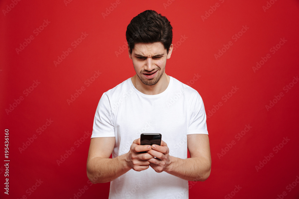 Portrait of a confused young man in white t-shirt Portrait of a confused young man in white t-shirt