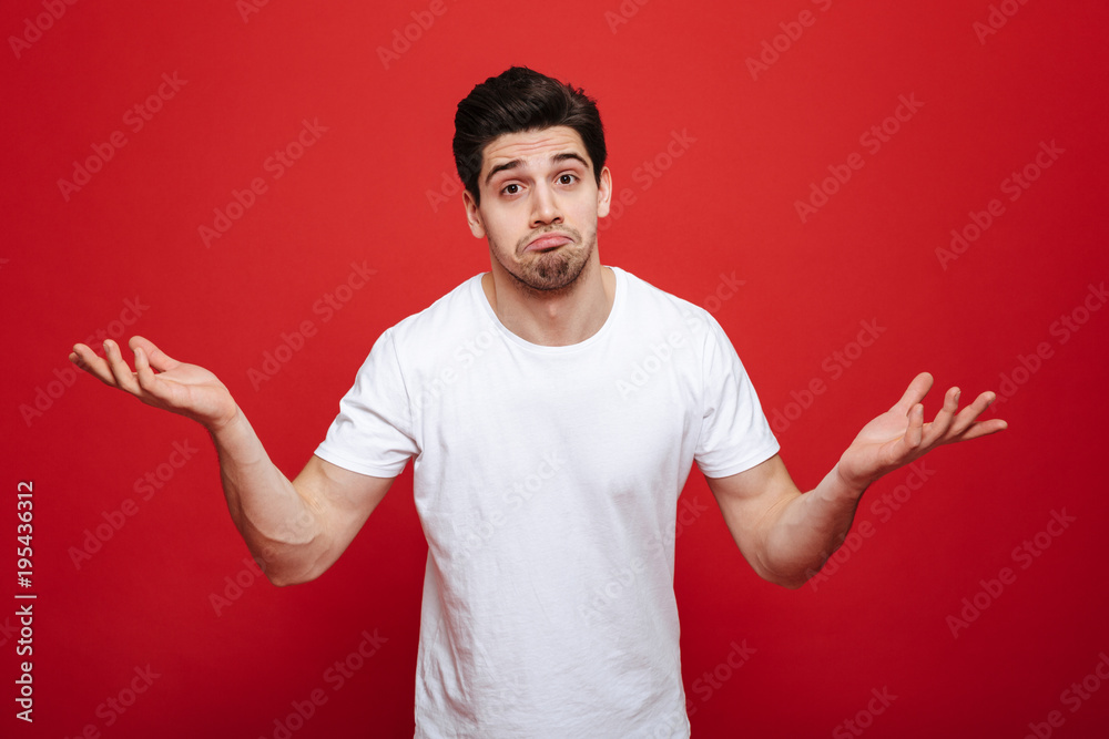 Portrait of a confused young man in white t-shirt Portrait of a confused young man in white t-shirt