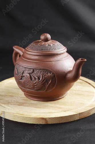 Clay teapot and on a wooden stand