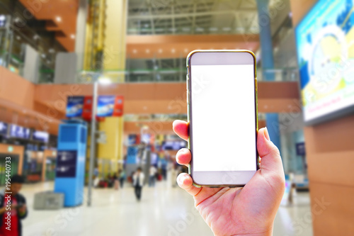 People hand use cellphone at the hall airport background with copy space on screen for using mobile app about activities in the airport or checking flight plan