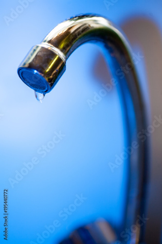 Tap with dripping waterdrop. Water leaking