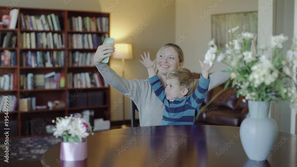 Young mother and her son taking a selfie on the sofa.Happy family. Young mother and her son taking a selfie on the sofa.Happy family.